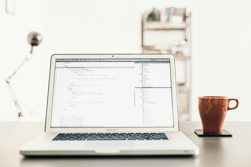 An open laptop and a mug on a bright desk.